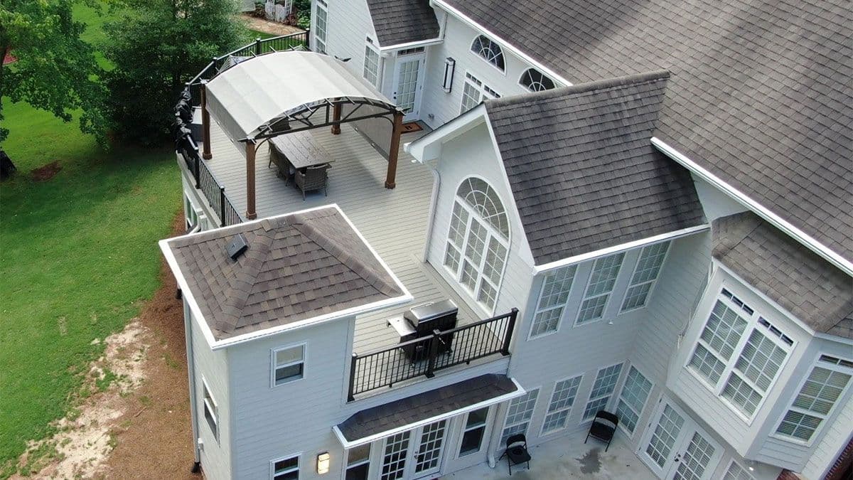 Open upper composite deck with an interior spiral staircase leading to sunroom with fireplace and underdeck system.